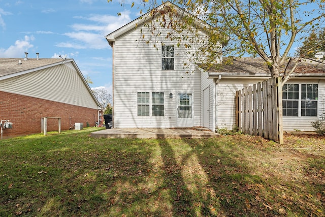 back of property with a yard and a patio