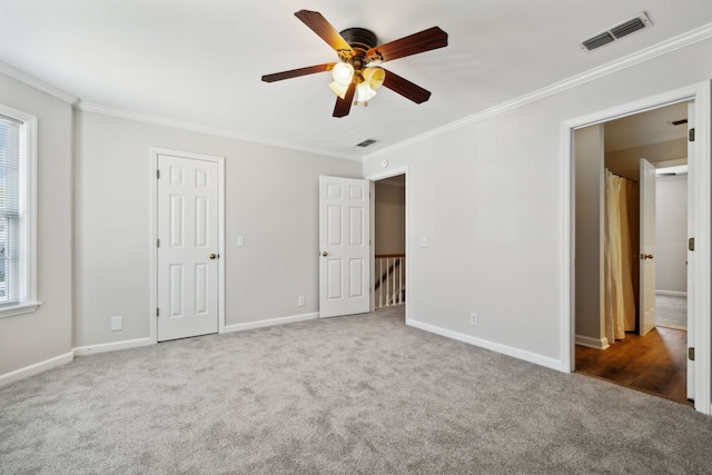 unfurnished bedroom featuring carpet floors, ceiling fan, and crown molding