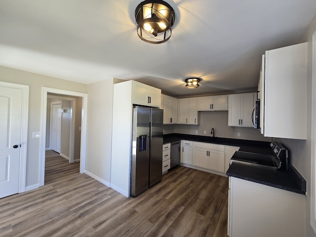 kitchen featuring dark hardwood / wood-style flooring, sink, white cabinets, and appliances with stainless steel finishes