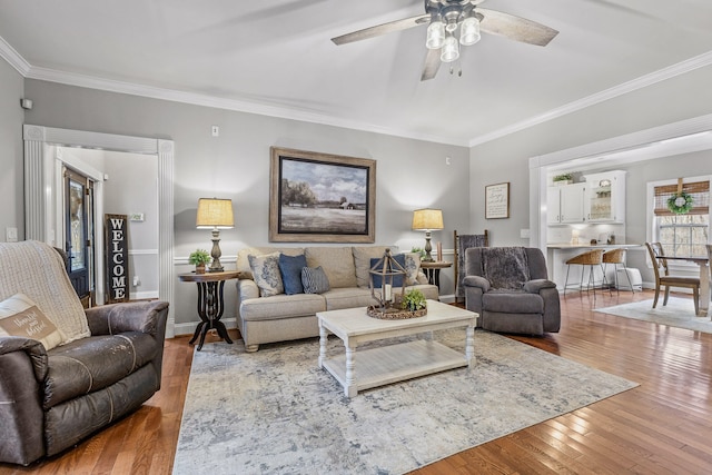 living room with ceiling fan, hardwood / wood-style floors, and ornamental molding