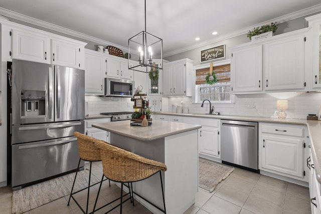 kitchen featuring white cabinets, a center island, stainless steel appliances, sink, and hanging light fixtures