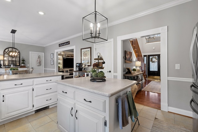 kitchen featuring pendant lighting, white cabinetry, a center island, and light tile patterned flooring