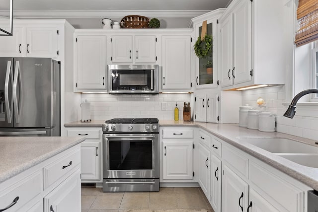 kitchen featuring sink, stainless steel appliances, white cabinets, and decorative backsplash