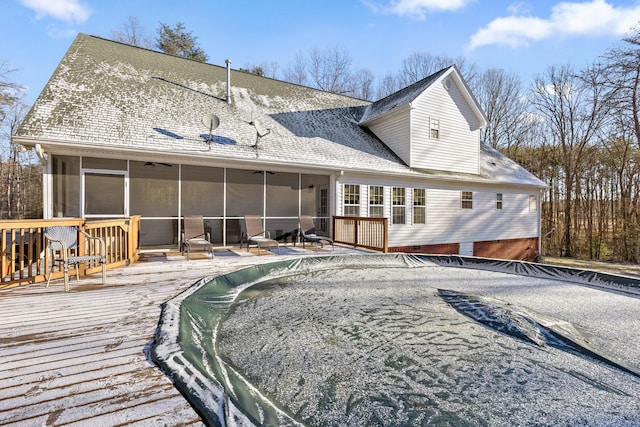 back of property with ceiling fan, a sunroom, and a swimming pool side deck