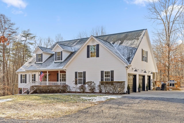 cape cod home with a garage and covered porch