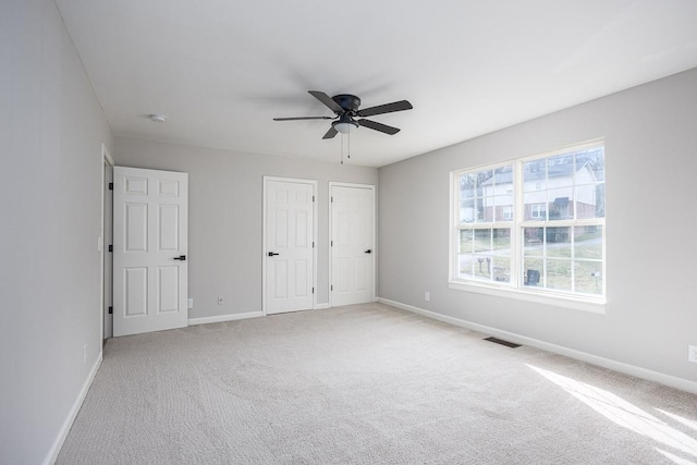 unfurnished bedroom featuring light carpet and ceiling fan