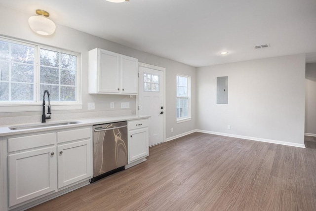 kitchen with dishwasher, electric panel, white cabinets, sink, and light hardwood / wood-style floors