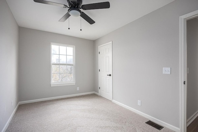 carpeted spare room with ceiling fan