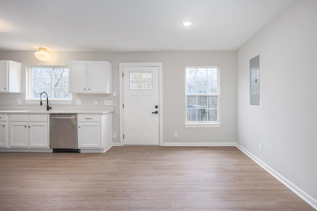 kitchen featuring stainless steel dishwasher, white cabinetry, sink, and a wealth of natural light