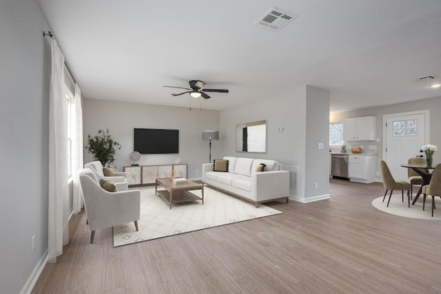 living room featuring light hardwood / wood-style floors and ceiling fan