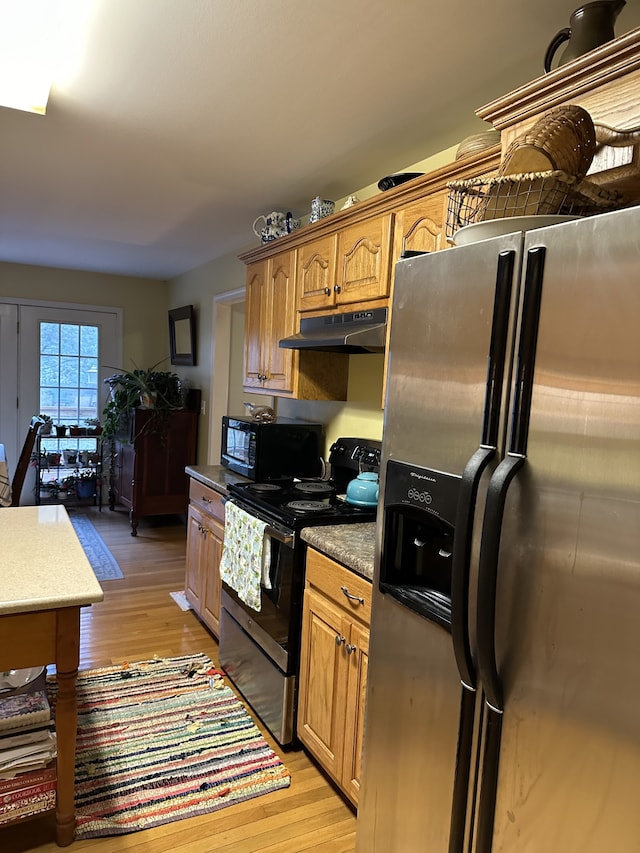 kitchen with stainless steel appliances and light hardwood / wood-style flooring