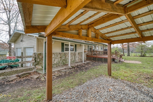 view of side of property with a garage, a deck, and a yard