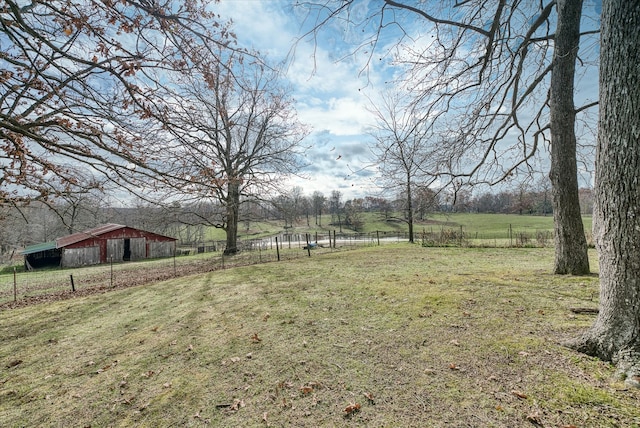 view of yard with a rural view and an outdoor structure