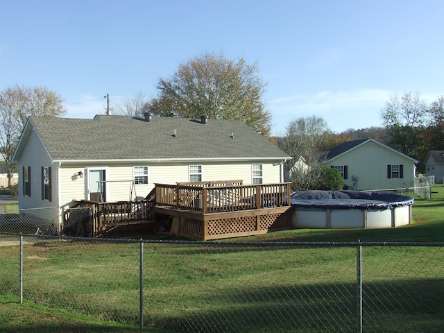 back of house with a swimming pool side deck and a yard