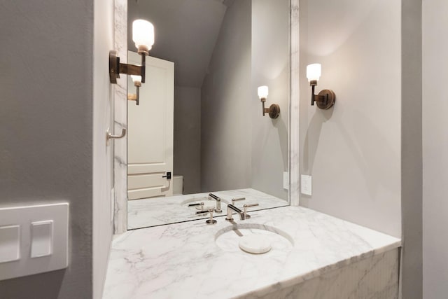 bathroom with vanity and vaulted ceiling