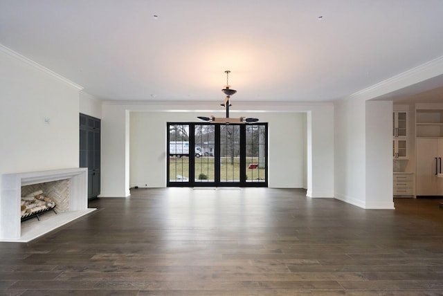 unfurnished living room featuring a notable chandelier, a fireplace, dark wood-style flooring, and ornamental molding