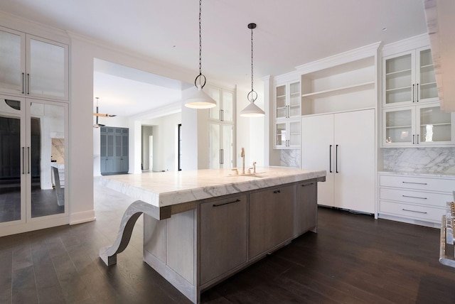 kitchen featuring a large island, white cabinets, open shelves, and a sink