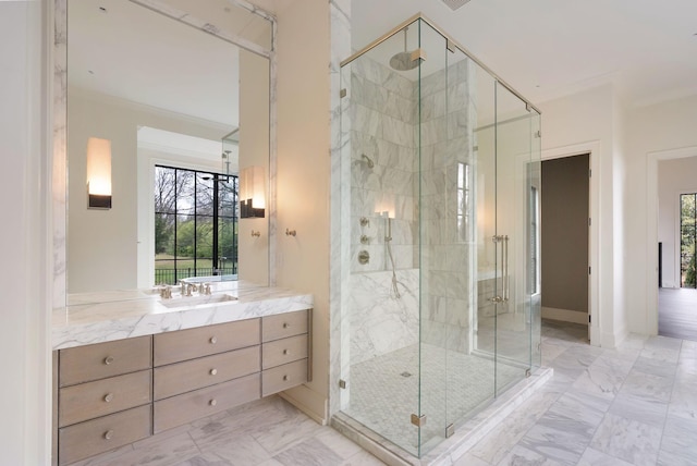 full bath with vanity, marble finish floor, a shower stall, and crown molding