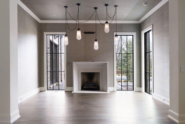 unfurnished living room with wood finished floors, a fireplace with raised hearth, and ornamental molding