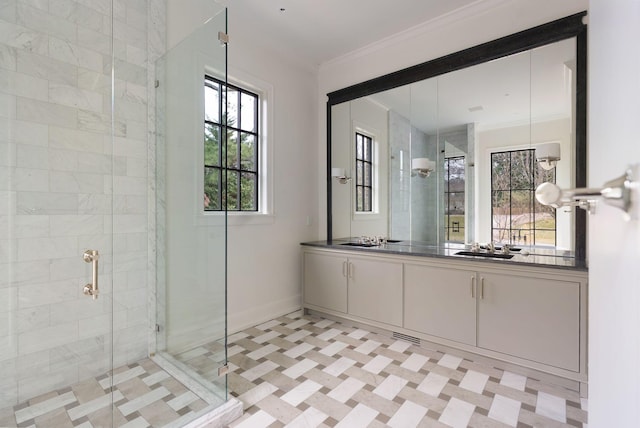 bathroom featuring a stall shower, vanity, crown molding, and baseboards