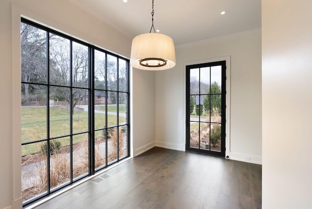 unfurnished room featuring visible vents, dark wood-style flooring, baseboards, and ornamental molding