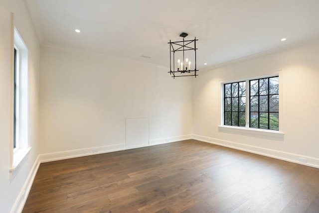 unfurnished room featuring dark wood-type flooring, ornamental molding, and a chandelier