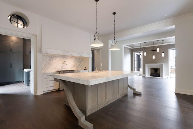 kitchen featuring dark wood-style floors, gas stove, a fireplace, ornamental molding, and backsplash