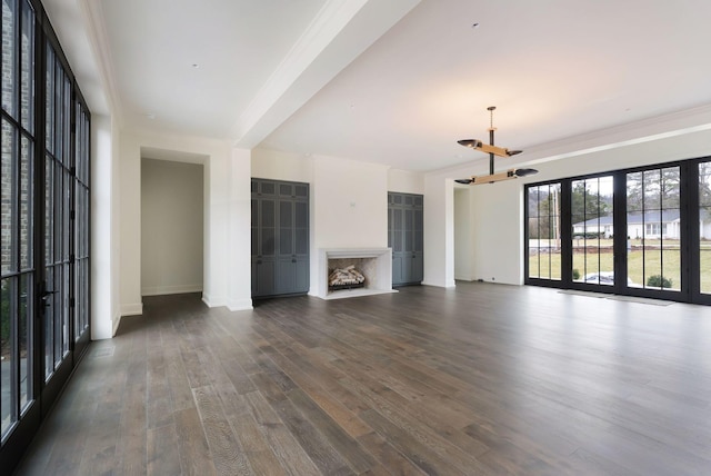 unfurnished living room with dark wood finished floors, a fireplace, baseboards, and ornamental molding