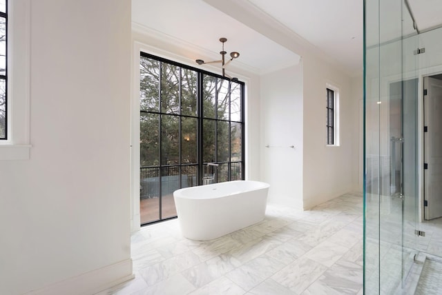 full bathroom featuring baseboards, a freestanding tub, a shower stall, crown molding, and marble finish floor