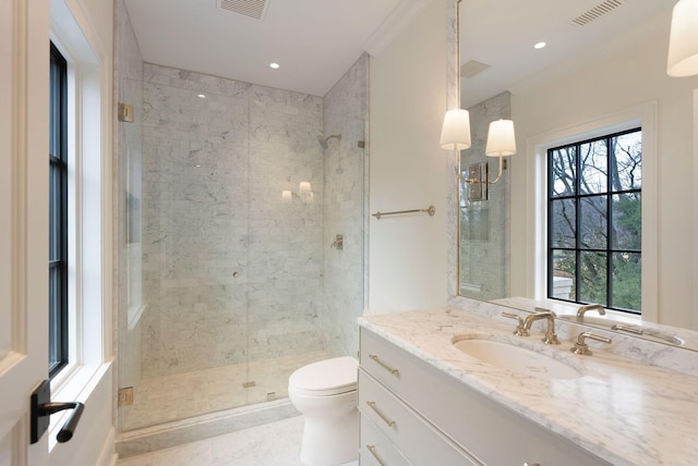 bathroom with vanity, a shower stall, toilet, and visible vents