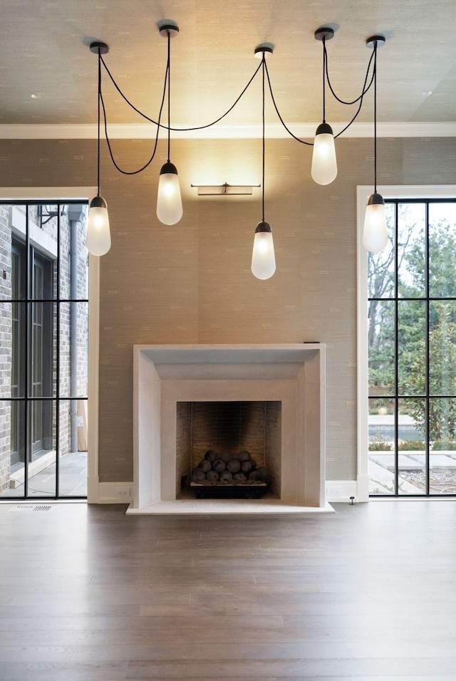 unfurnished living room with a fireplace, crown molding, and wood finished floors