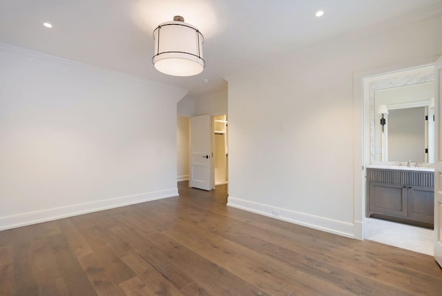 unfurnished room with ornamental molding, baseboards, and wood finished floors