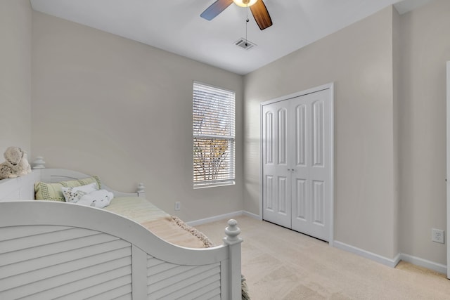 carpeted bedroom featuring ceiling fan and a closet