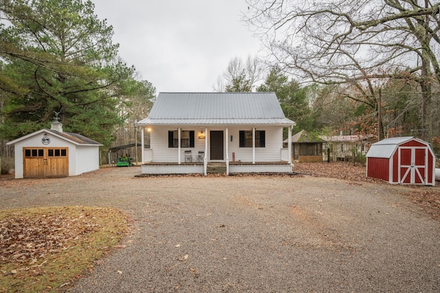 view of front facade featuring a porch, a shed, and a garage