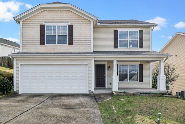 front facade with covered porch, a garage, and a front lawn