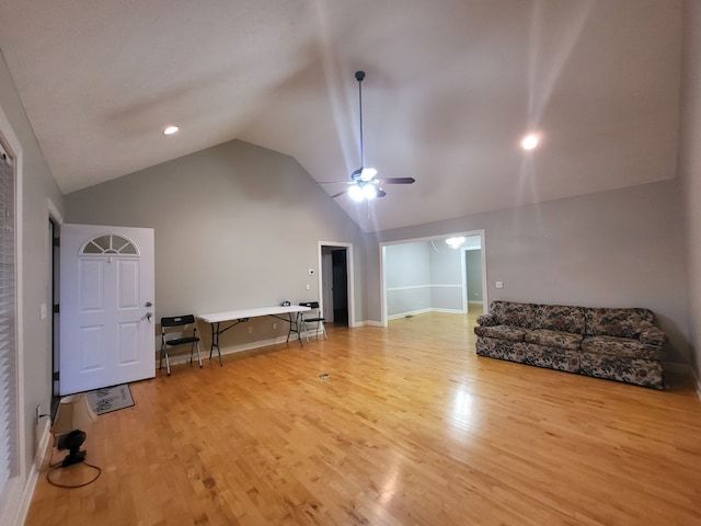 living room featuring ceiling fan, light hardwood / wood-style flooring, and lofted ceiling