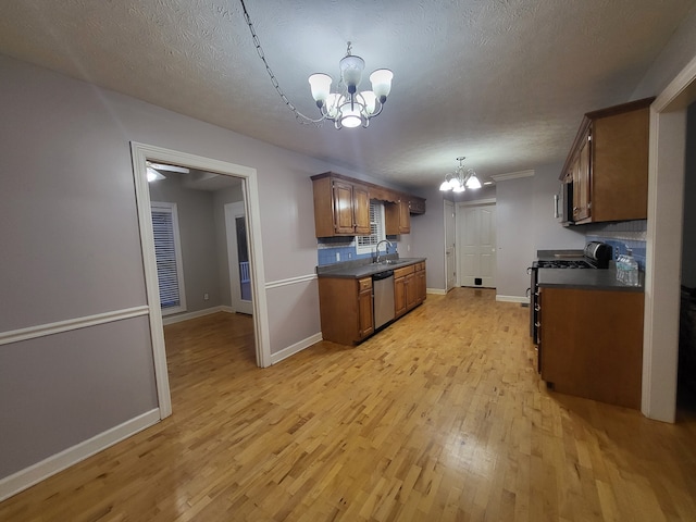 kitchen with light wood-type flooring, backsplash, sink, black range, and a chandelier