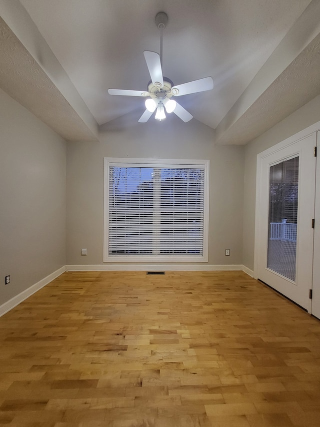 unfurnished room with ceiling fan, light hardwood / wood-style floors, vaulted ceiling, and french doors