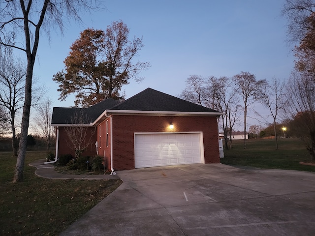 property exterior at dusk featuring a lawn and a garage