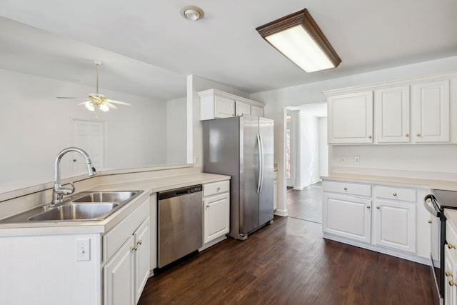 kitchen with appliances with stainless steel finishes, sink, white cabinets, dark hardwood / wood-style flooring, and kitchen peninsula