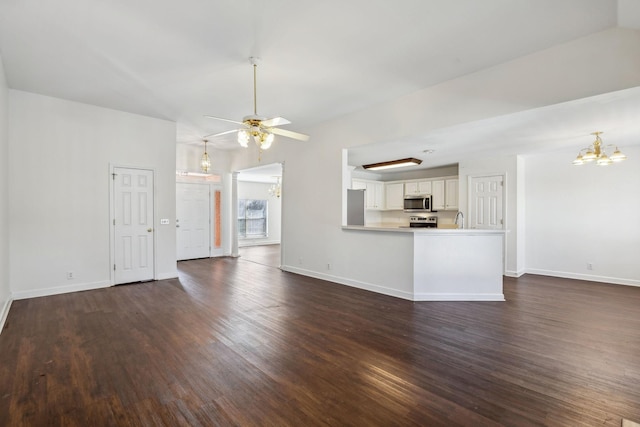 unfurnished living room featuring sink, ceiling fan with notable chandelier, and dark hardwood / wood-style flooring