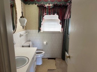 full bathroom featuring vanity, toilet, tile walls, and bathtub / shower combination