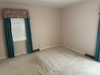 unfurnished room featuring light colored carpet