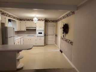 kitchen featuring light carpet, white appliances, ventilation hood, and white cabinetry