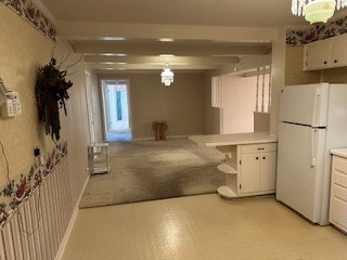 kitchen featuring white cabinetry, light carpet, and white refrigerator