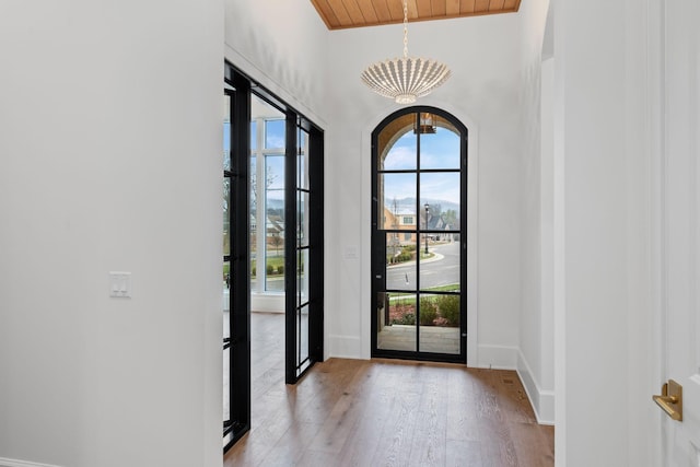 entryway featuring light wood-type flooring, baseboards, and arched walkways