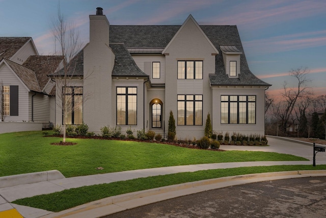 view of front facade featuring a chimney and a front lawn