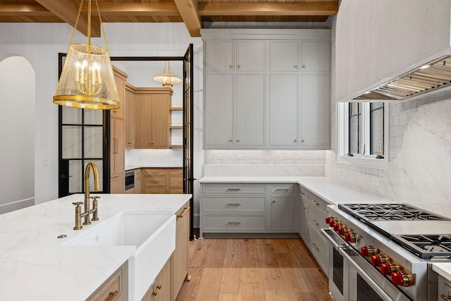 kitchen featuring light wood-style floors, custom exhaust hood, gray cabinets, double oven range, and decorative light fixtures