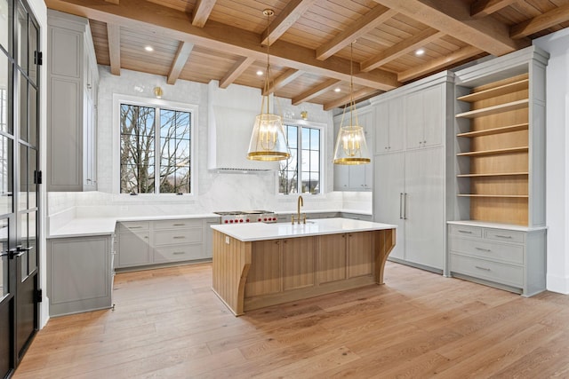 kitchen with an island with sink, gray cabinets, and light countertops