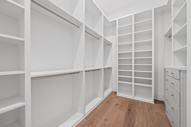 walk in closet with wood finished floors